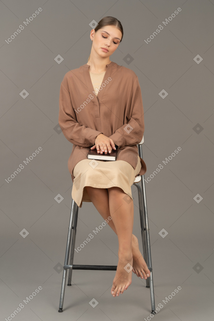 Woman sitting on chair with closed eyes