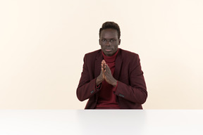 Elegant black man sitting at the table in the office