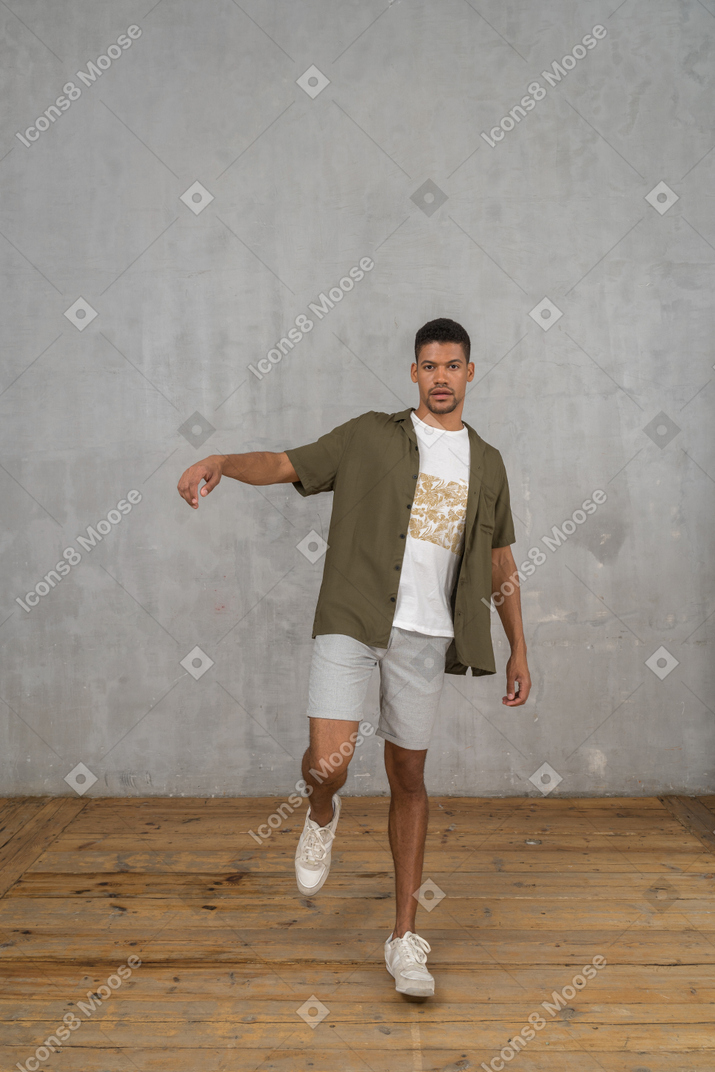 Man standing on one leg with raised arm