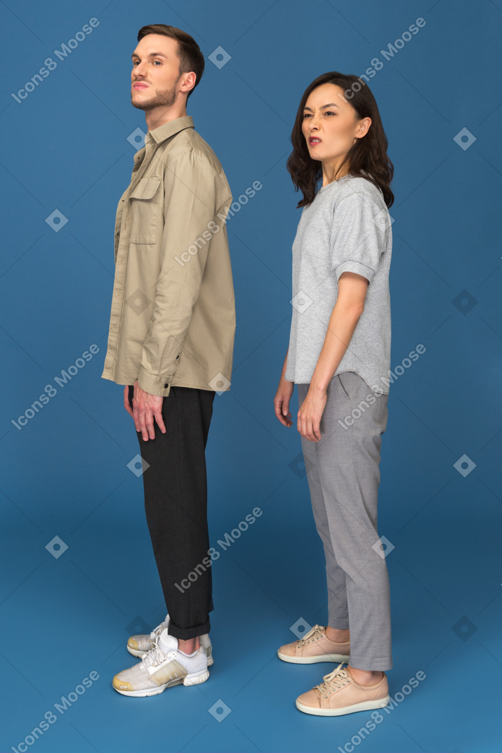 Young man and woman looking sideways with disgust