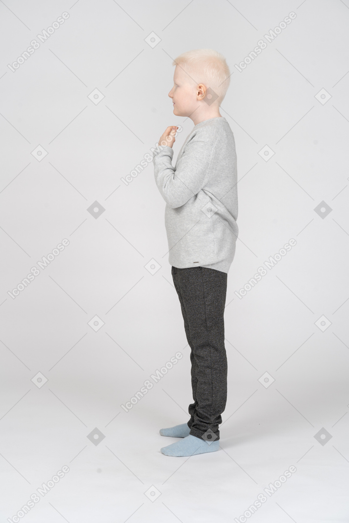 Side view of a little boy with raised arms