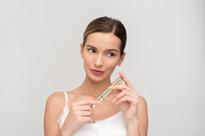 Beautiful young woman holding mascara