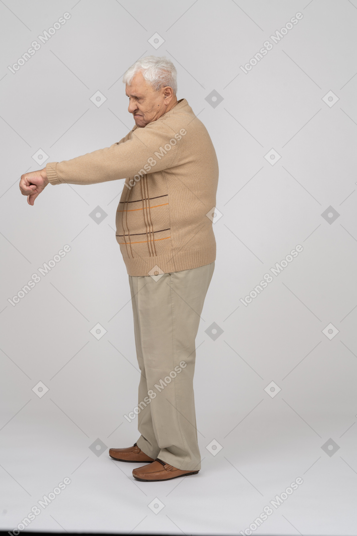 Seitenansicht eines alten mannes in freizeitkleidung mit daumen nach unten
