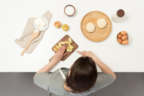 A female baker cutting apples