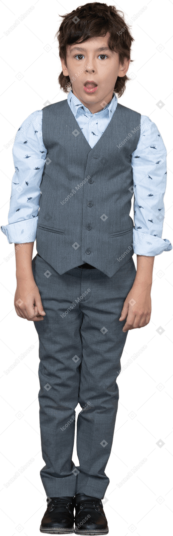 Vista frontale di un ragazzo carino in abito grigio in piedi con la bocca aperta