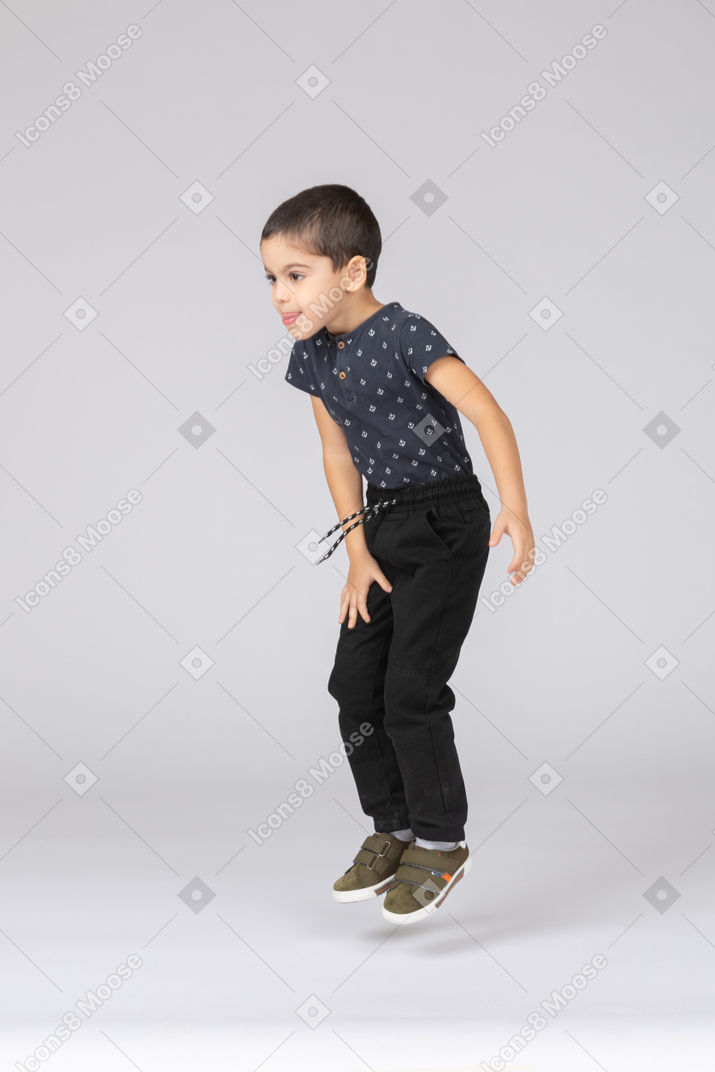 Side view of a cute boy jumping