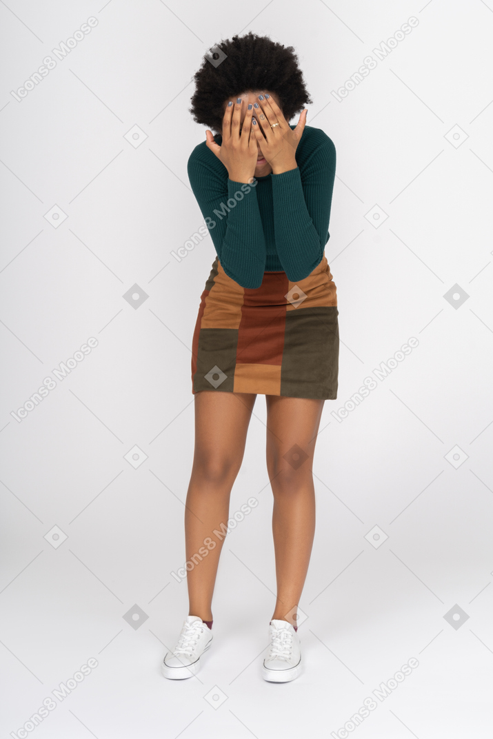 Slim african girl covering face with both hands