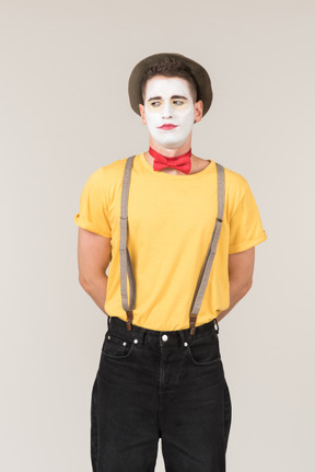 Male clown standing with his hands behind his back