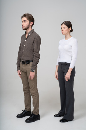 Three-quarter view of a young pouting couple in office clothing