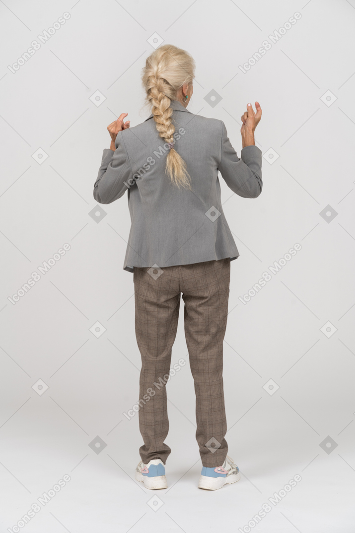 Back view of an old lady in suit explaining something