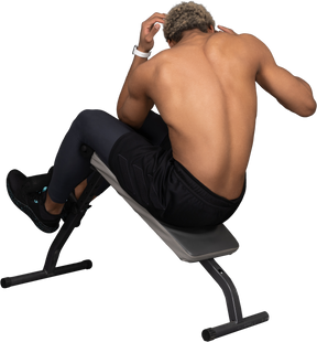 Three-quarter back view of a shirtless afro man doing crunches