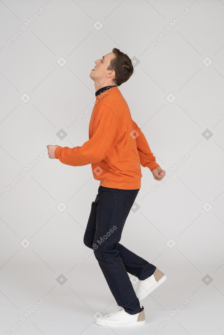 Joven en sudadera naranja saltando