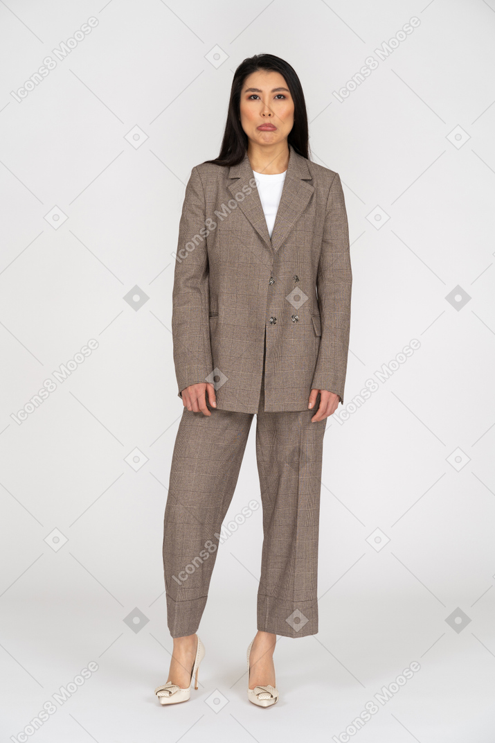 Front view of a displeased pouting young lady in brown business suit