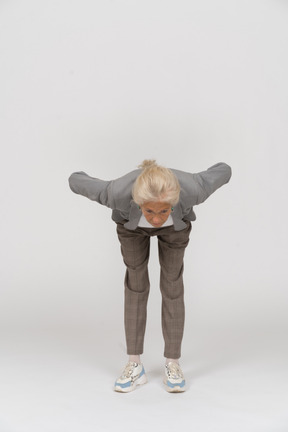 Front view of an old lady in suit bending down