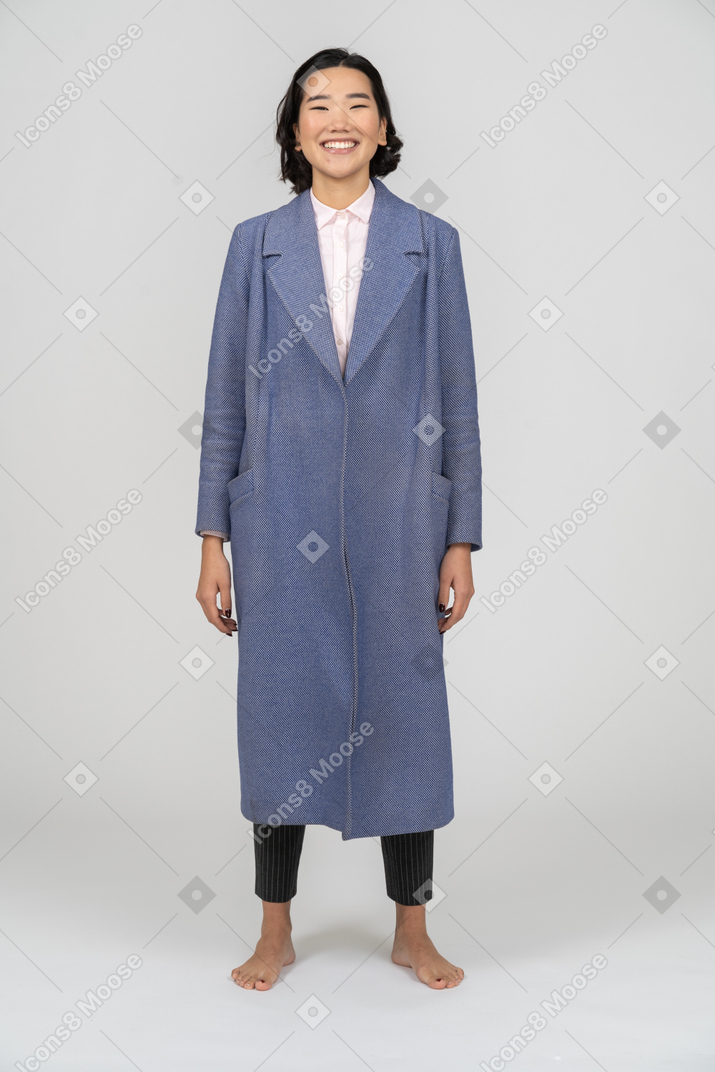 Woman in blue coat smiling happily