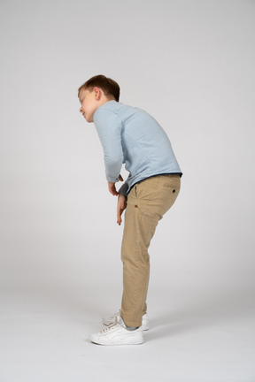 Side view of a boy bending down