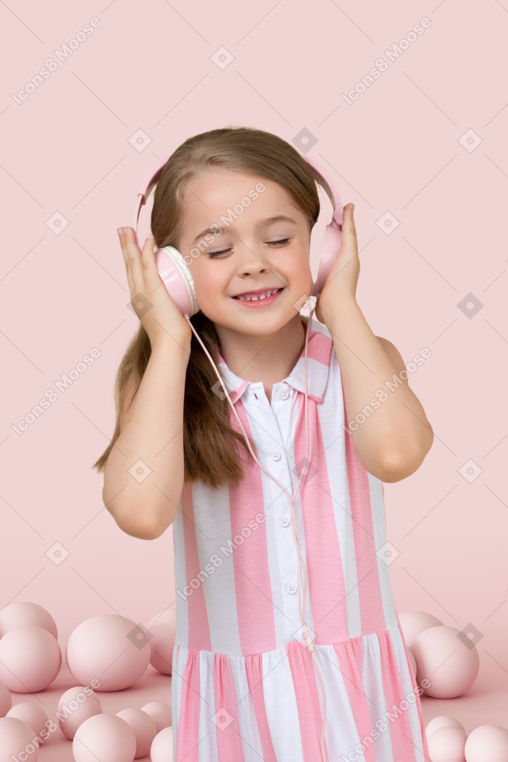 Kleines mädchen mit kopfhörern, die musik hören