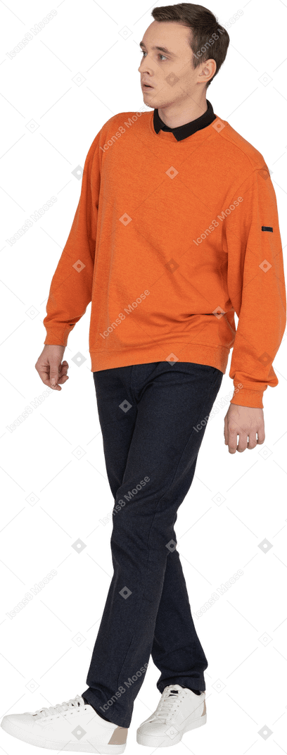 Young man in orange sweatshirt walking