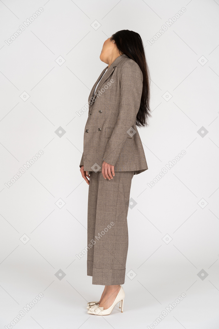 一位年轻女士在棕色西装转身的侧视图
