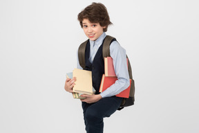 Schoolboy carrying a bunch of books