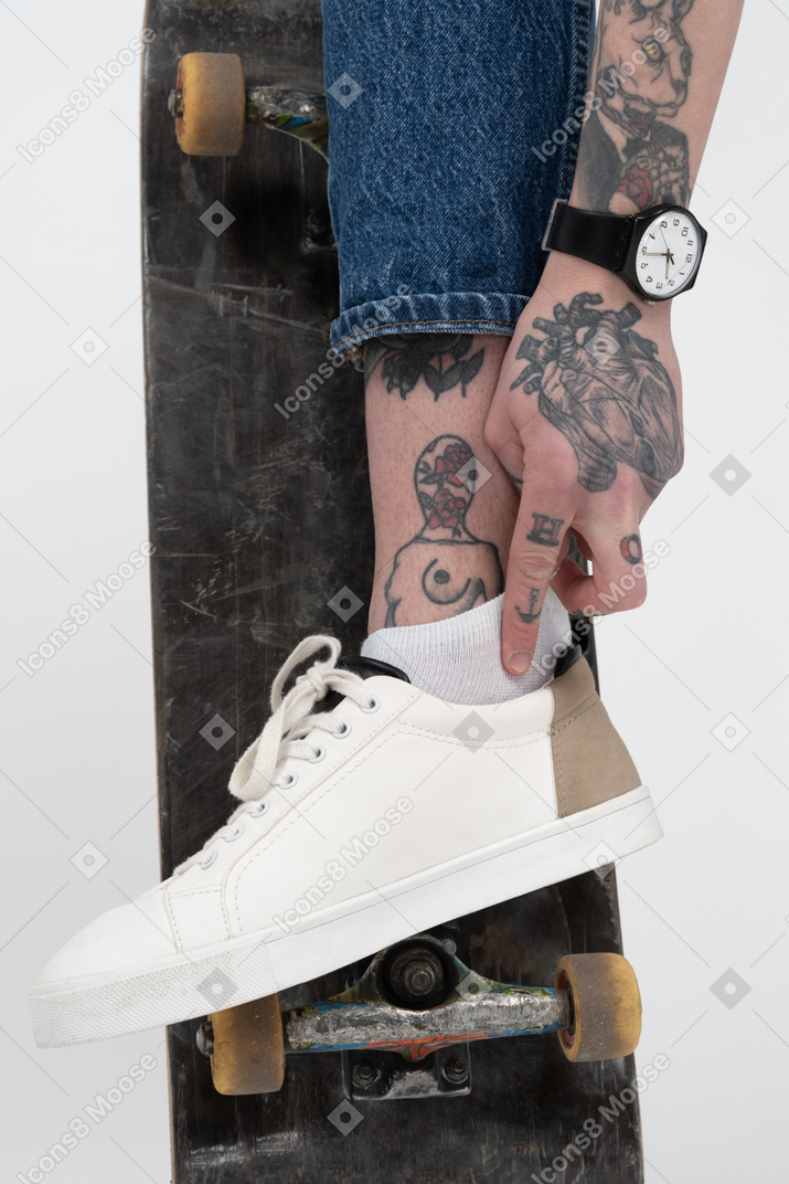 Tattooed person wearing sneakers