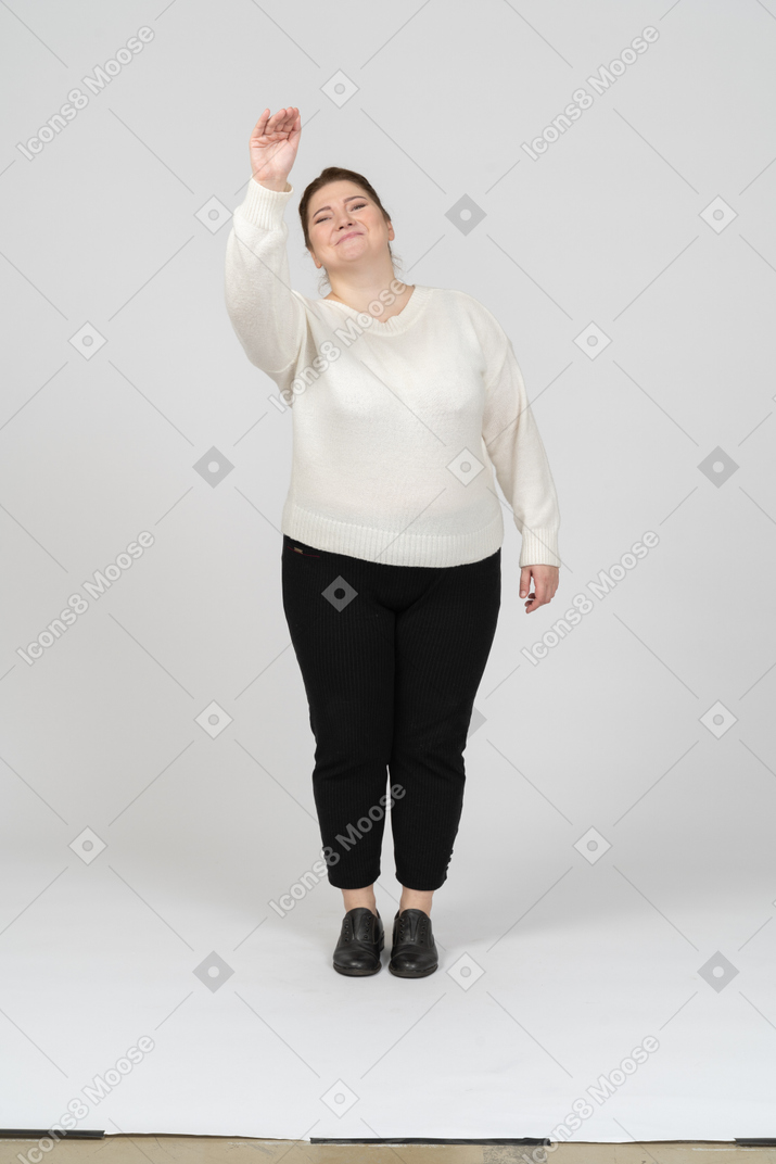 Vista frontal de una mujer de talla grande en ropa casual saludando a alguien