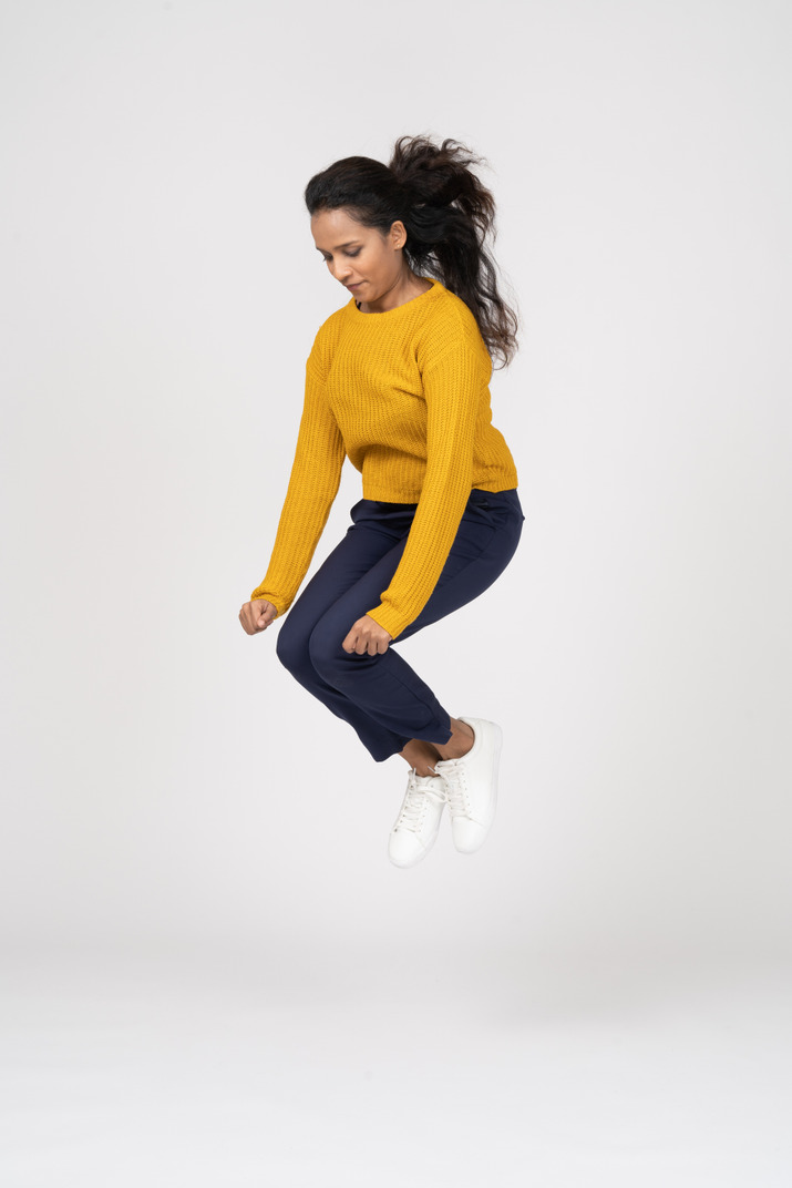 Side view of a girl in casual clothes jumping