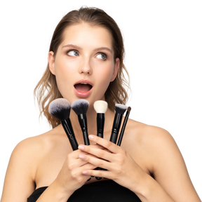 Front view of a surprised young woman holding make-up brushes