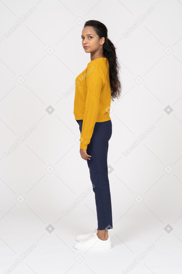 Side view of a girl in casual clothes looking at camera