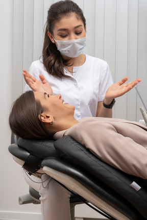 A female dentist and her patient talking