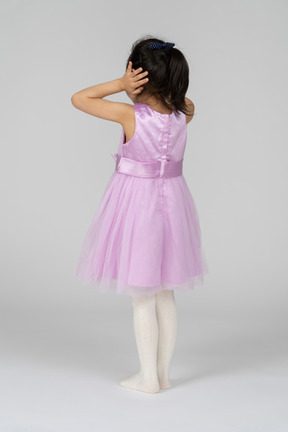 그녀의 귀를 닫고 핑크 드레스 소녀