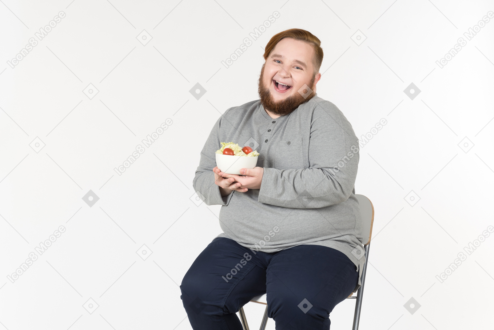 Rire gros homme barbu tenant une assiette de salade