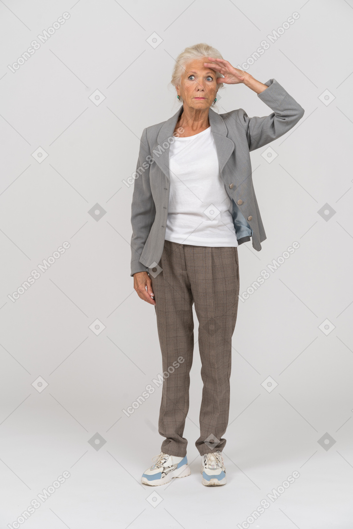 一位身着西装的老太太正在寻找某人的前视图