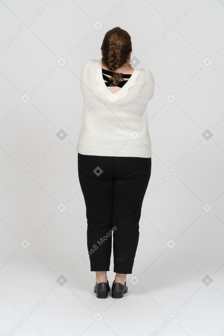 Vista posteriore di una donna grassoccia in maglione bianco in posa