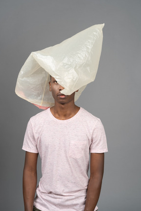 Close-up unemotional african male with a plastic pocket hiding his face