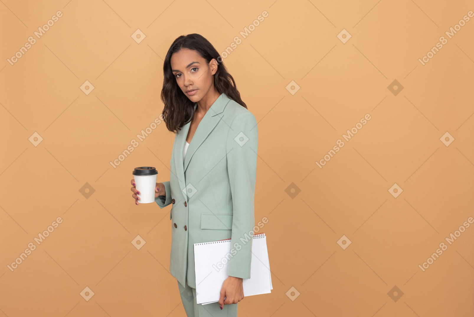 Attraktive junge frau, die einen kaffee und ein bündel papiere hält