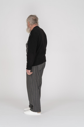 Back view of old man in dark clothes standing
