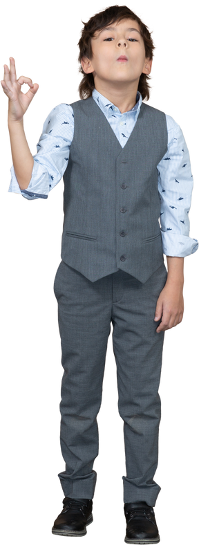 Vista frontale di un ragazzo in abito grigio che mostra segno ok