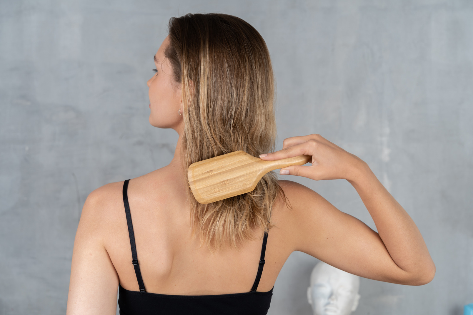 Back view of a young woman brushing her hair