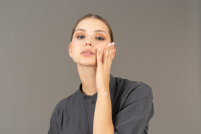 Front view of a young woman in a jumpsuit removing make-up