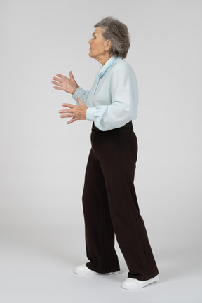 Vista laterale di una donna anziana che gesturing preoccupata