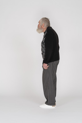Vista lateral de um homem idoso de pé e olhando para longe