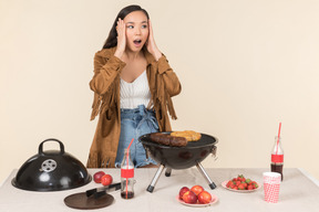 Young asian girl having problem with barbecue