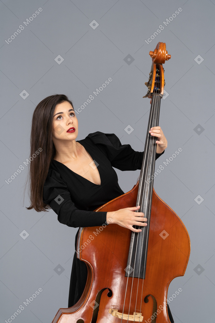 Close-up of a young woman in black dress playing her double-bass