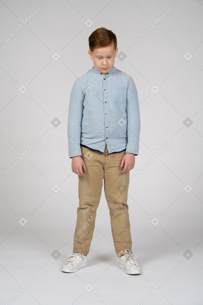 一个穿着休闲服的男孩低着头的正面图