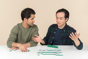 Amigos interraciales sentados a la mesa y jugando scramble