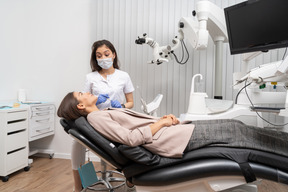 Full-length of a female dentist consulting her female patient in a hospital cabinet