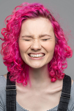 Portrait d'une fille aux cheveux rose heureuse excitée