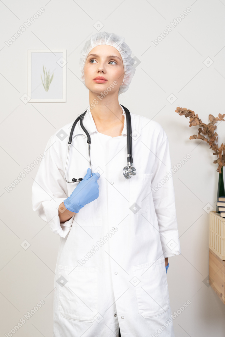 Vue de face d'une jeune femme médecin tenant un stéthoscope