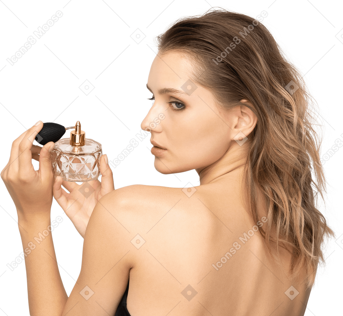 Back view of a sensual young woman holding a bottle of perfume
